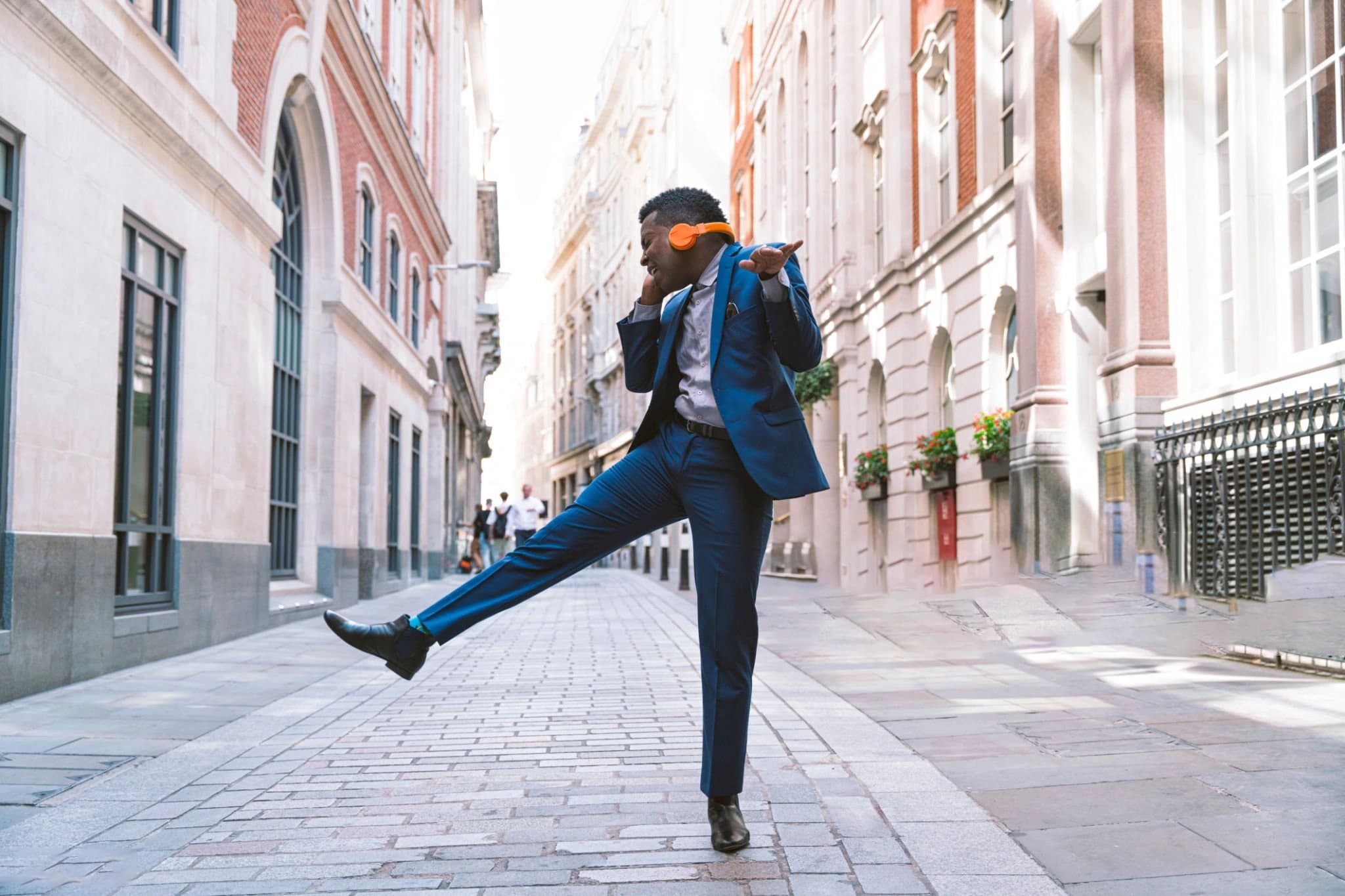 Person making an expressive movement on a city street.