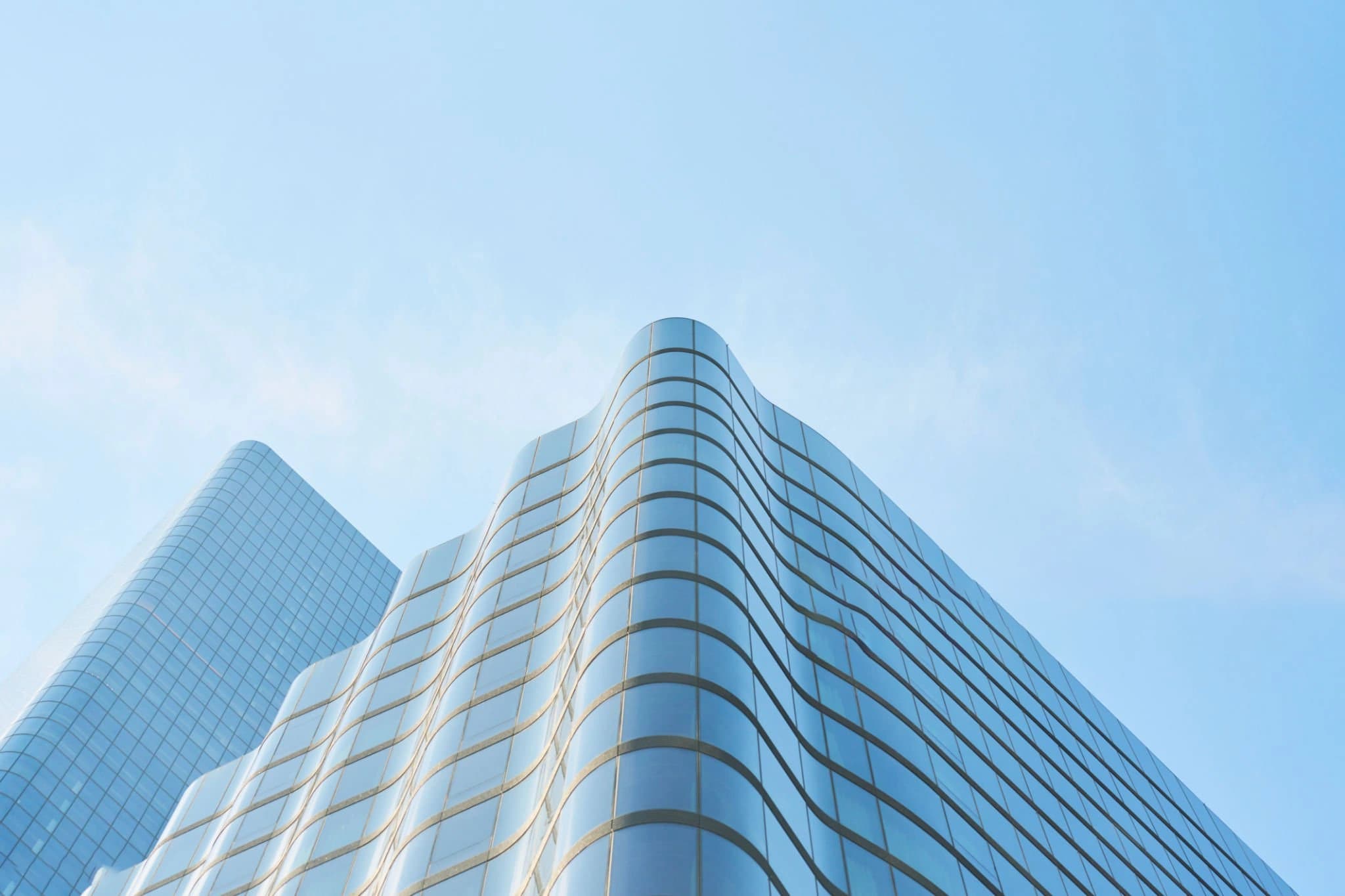 Curved modern building rising into a blue sky.